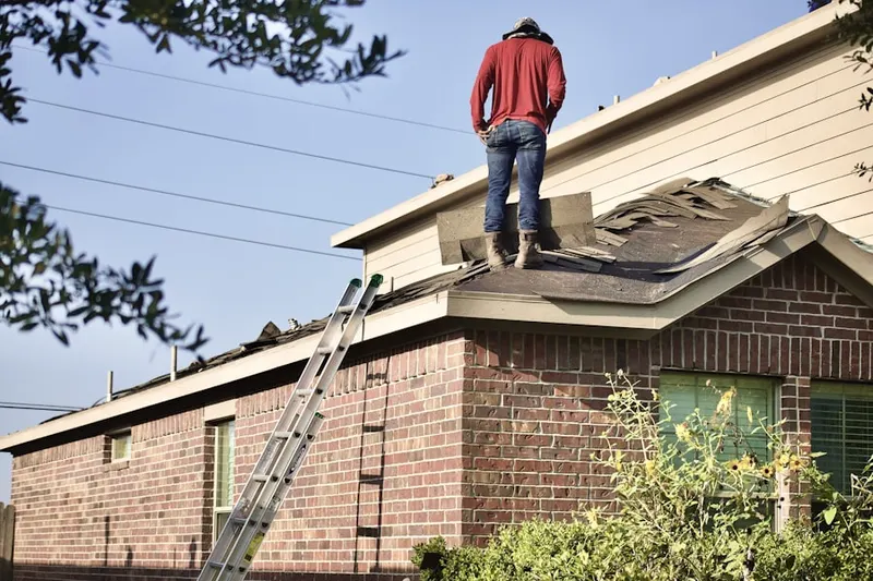 Professional roofer working on a residential roof in Camp Wampatuck